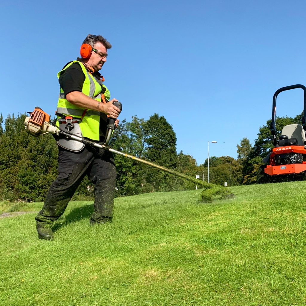 Murray Landscapes operative strimming grass verges on a commercial estate